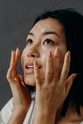 Female applying moisturizer to her face